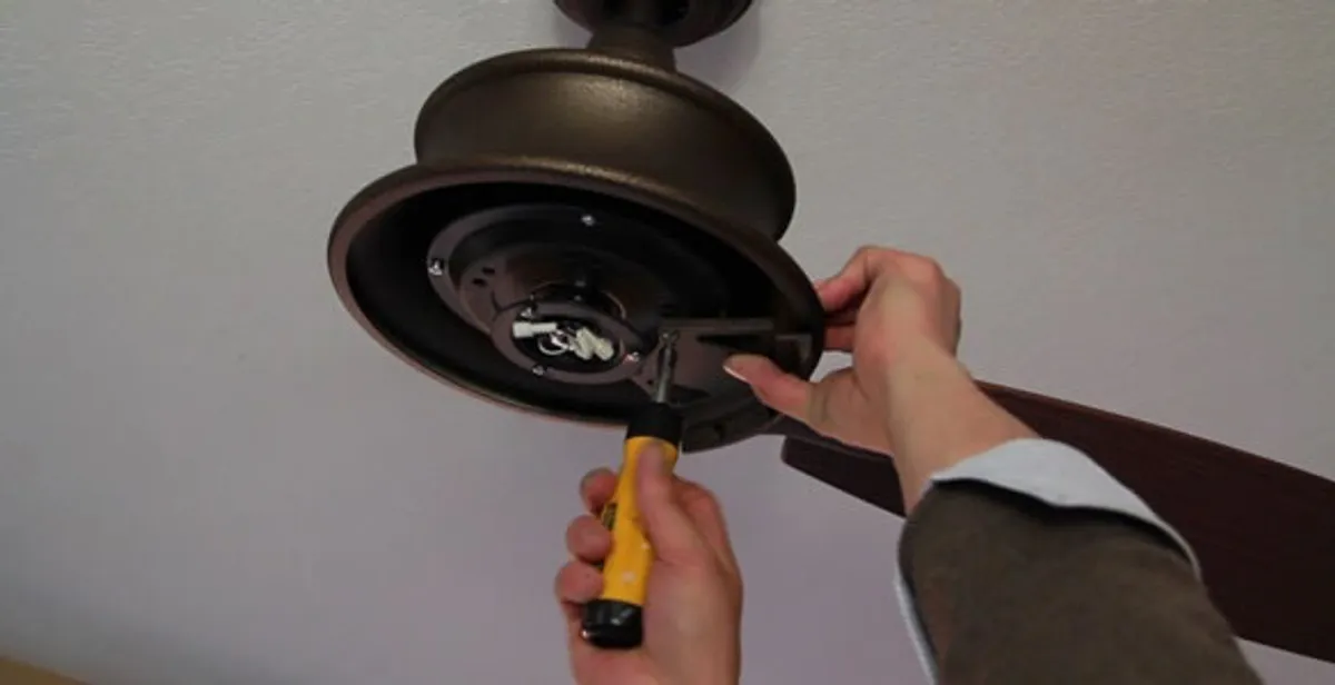 Electrician installing ceiling fan mounting bracket and fixture in Seattle, WA