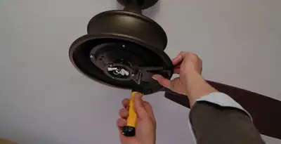 Electrician installing ceiling fan mounting bracket and fixture in Seattle, WA