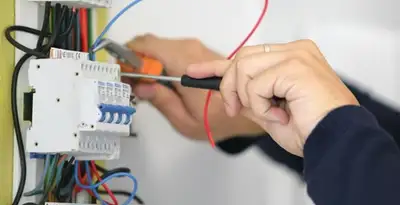 Electrician installing and adjusting circuit breakers in an electrical panel in Seattle, WA