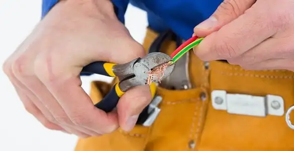 licensed electrician securing electrical wiring with professional tools during service work in Seattle, WA