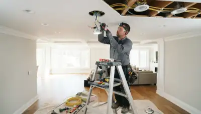 Electrician installing recessed lighting in a Seattle, WA home